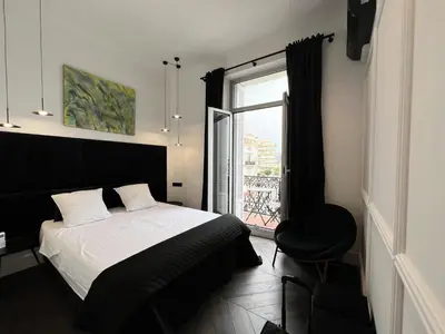 a bedroom with a bed and a window and a chair at Luxury Cannes in Cannes