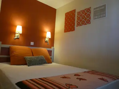 a bed in a room with two lights on the wall at Cannes vue mer appt 4pers in Cannes