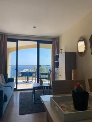 a living room with a couch and a kitchen with a view at Cannes vue mer appt 4pers in Cannes