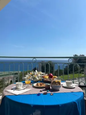 a table with a blue table cloth with food on it at Cannes vue mer appt 4pers in Cannes
