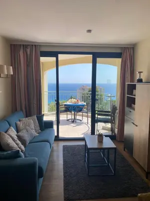 a living room with a blue couch and a view of the ocean at Cannes vue mer appt 4pers in Cannes