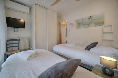 a room with two beds and a tv on the wall at One Bed Apt in the center of Cannes - 2198 in Cannes