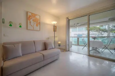 a living room with a couch and a sliding glass door at One Bed Apt in the center of Cannes - 2198 in Cannes