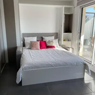 a bedroom with a large white bed with pink pillows at Top Floor Secret Garden, Cannes in Cannes