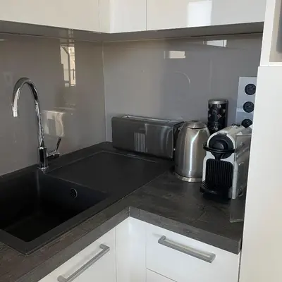 a kitchen with a black counter top with a sink at Top Floor Secret Garden, Cannes in Cannes