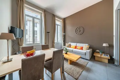 a living room with a table and a couch at Beautiful 2 bedroom in the heart of Cannes in Cannes