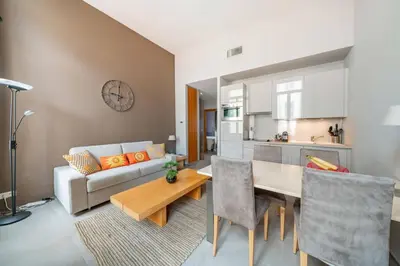 a living room with a white couch and a table at Beautiful 2 bedroom in the heart of Cannes in Cannes