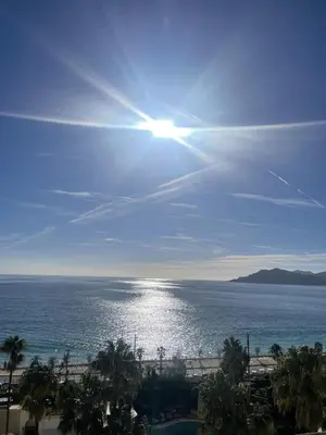 a balcony with a table and a view of the ocean at La Perla del Mare in Cannes