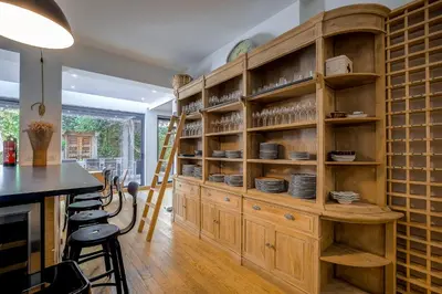 a kitchen with a large wooden cabinet with plates on it at Superbe appartement T5 proche du Palais et de la Croisette in Cannes