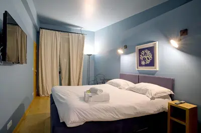 a bedroom with a bed with white sheets and pillows at Superbe appartement T5 proche du Palais et de la Croisette in Cannes