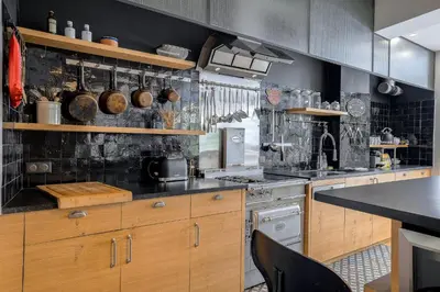 a kitchen with wooden cabinets and a stove at Superbe appartement T5 proche du Palais et de la Croisette in Cannes