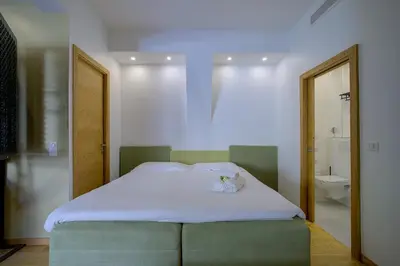 a bedroom with a bed and a bathroom with a toilet at Superbe appartement T5 proche du Palais et de la Croisette in Cannes