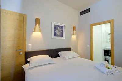 a bedroom with a large white bed with two pillows at Superbe appartement T5 proche du Palais et de la Croisette in Cannes