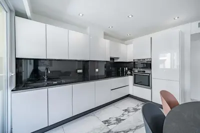 a kitchen with white cabinets and black appliances at Beautiful 3 bedroom close to the Martinez in Cannes