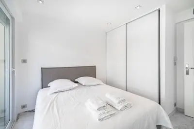 a white bedroom with a bed with two towels on it at Beautiful 3 bedroom close to the Martinez in Cannes