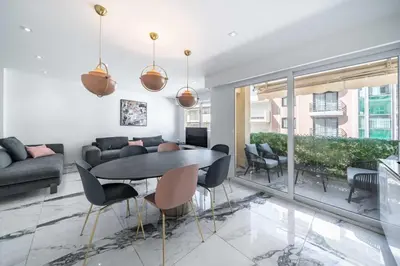 a living room with a table and chairs at Beautiful 3 bedroom close to the Martinez in Cannes