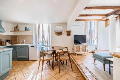 a kitchen and living room with a table and chairs at Charming apartment heart of Suquet neighborhood in Cannes