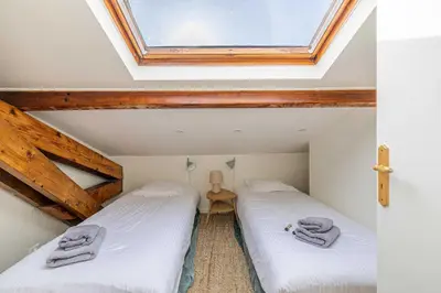 two twin beds in a room with a skylight at Charming apartment heart of Suquet neighborhood in Cannes
