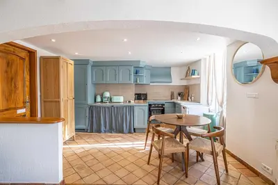 a kitchen with blue cabinets and a table and chairs at Charming apartment heart of Suquet neighborhood in Cannes