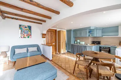 a living room with a table and a kitchen at Charming apartment heart of Suquet neighborhood in Cannes