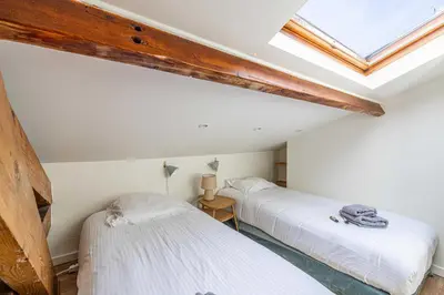 two twin beds in a room with a skylight at Charming apartment heart of Suquet neighborhood in Cannes