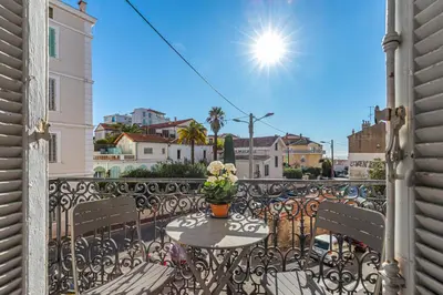 a patio with a table and chairs on a balcony at 77 Avenue de Grasse in Cannes