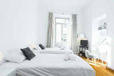 two beds in a white room with a window at 77 Avenue de Grasse in Cannes