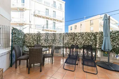 a group of chairs and an umbrella on a patio at 77 Avenue de Grasse in Cannes