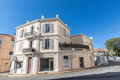 a white building on the corner of a street at 77 Avenue de Grasse in Cannes