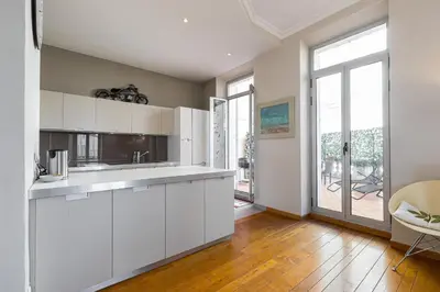 a kitchen with white cabinets and a large window at 77 Avenue de Grasse in Cannes