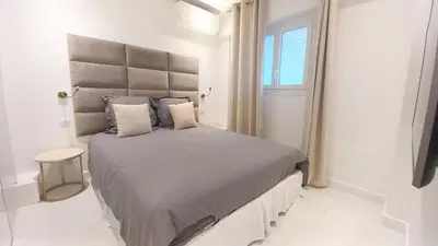 a bedroom with a large bed with a large headboard at Le Palais Des Iles in Cannes