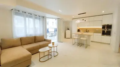 a living room with a couch and a kitchen at Le Palais Des Iles in Cannes