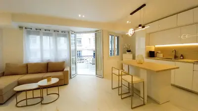 a living room and kitchen with a couch and a table at Le Palais Des Iles in Cannes