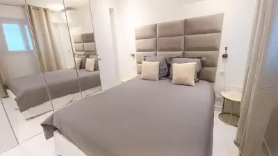 a bedroom with a large bed and a mirror at Le Palais Des Iles in Cannes