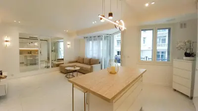 a kitchen and living room with a table and a couch at Le Palais Des Iles in Cannes