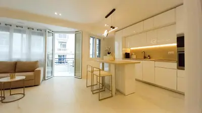 a kitchen and living room with a couch and a table at Le Palais Des Iles in Cannes