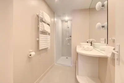 a white bathroom with a shower and a sink at Alma Florian apartment 4 people with terrace in Cannes
