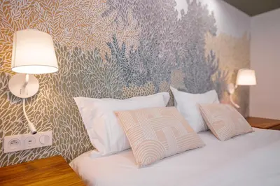 a bedroom with a bed with two pillows and a wallpaper at Alma Florian apartment 4 people with terrace in Cannes