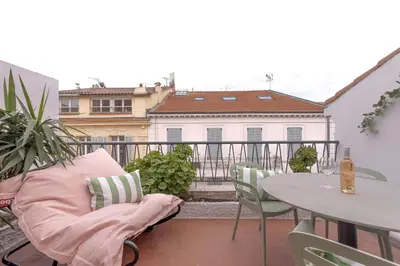 a balcony with a chair and a table and a building at Alma Florian apartment 4 people with terrace in Cannes