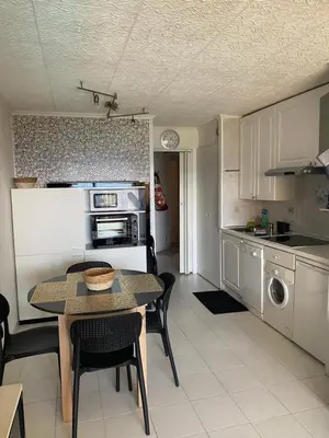 a kitchen with a table and a dining room at Bord de mer, terrasse, tout à pieds in Cannes