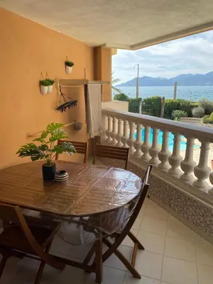 a dining room with a table and a balcony at Bord de mer, terrasse, tout à pieds in Cannes
