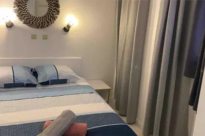 a bedroom with a bed and a mirror on the wall at Bord de mer, terrasse, tout à pieds in Cannes
