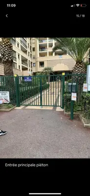 a gate in front of a building with a palm tree at Bord de mer, terrasse, tout à pieds in Cannes