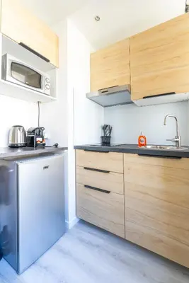 a kitchen with wooden cabinets and a sink at Studio centre Cannes in Cannes
