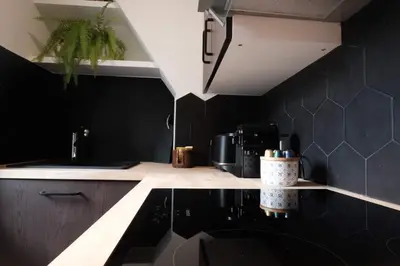 a kitchen with black walls and a black counter top at Studio Cannes - 5mn Palais des Festivals (400m) in Cannes
