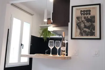 a shelf with two wine glasses and a poster at Studio Cannes - 5mn Palais des Festivals (400m) in Cannes