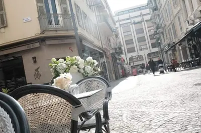 a table and chairs on a street with a bouquet of flowers at Studio Cannes - 5mn Palais des Festivals (400m) in Cannes