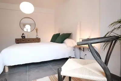 a bedroom with a white bed and a chair at Studio Cannes - 5mn Palais des Festivals (400m) in Cannes