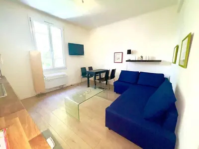 a living room with a blue couch and a table at Le Canada - 2Pièces Croisette plage derrière le Carlton calme in Cannes