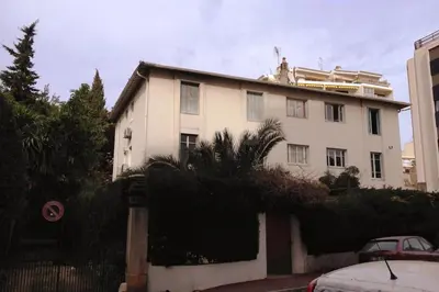 a white house with a fence in front of it at Le Canada - 2Pièces Croisette plage derrière le Carlton calme in Cannes